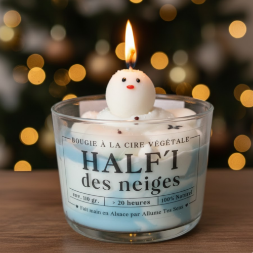 Détail d'une bougie gourmande Allume Tes Sens avec une chantilly de cire bleue et blanche et un petit bonhomme de neige artisanal sur le dessus